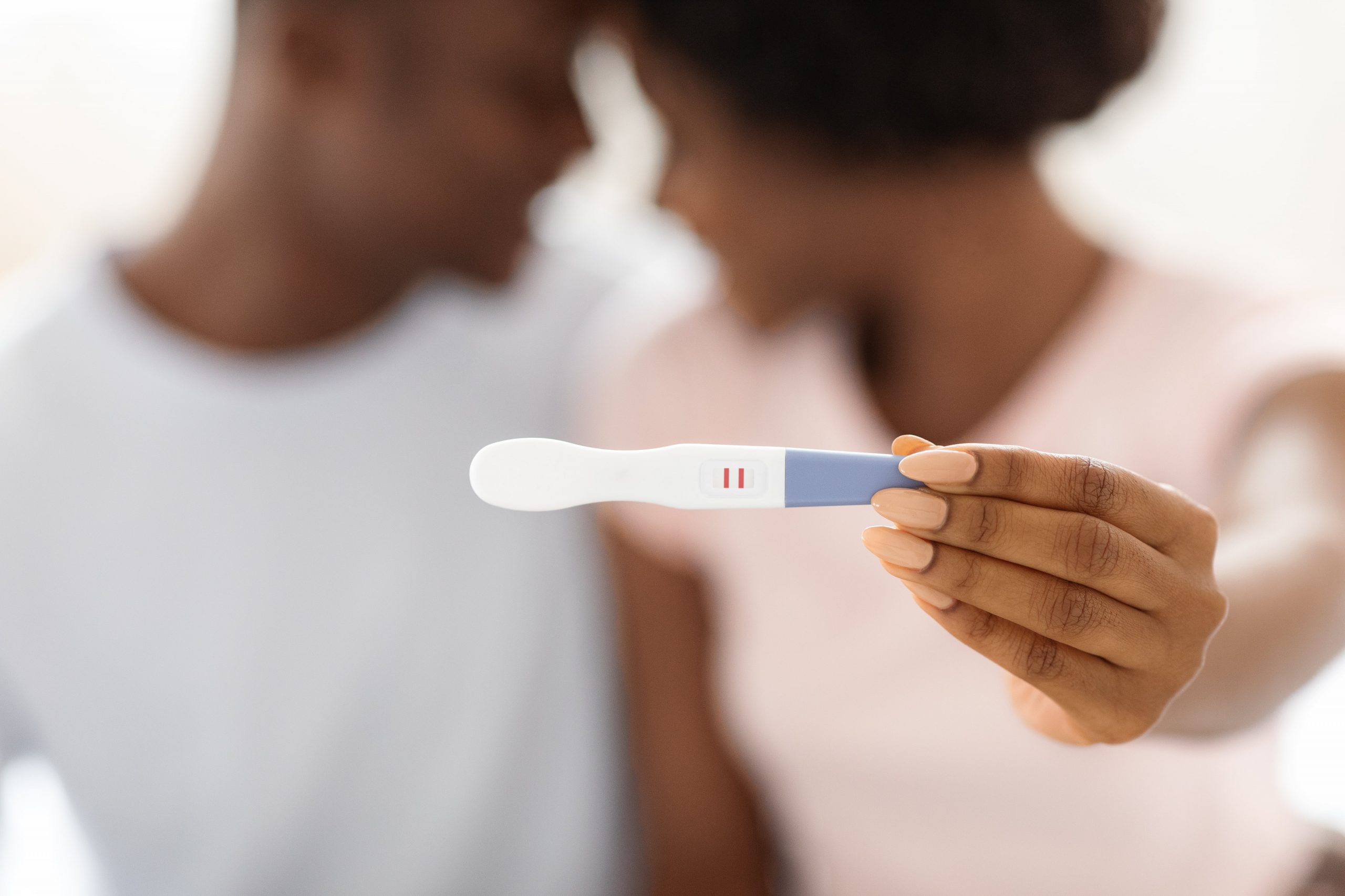 Couple showing positive pregnancy test after TTC naturally