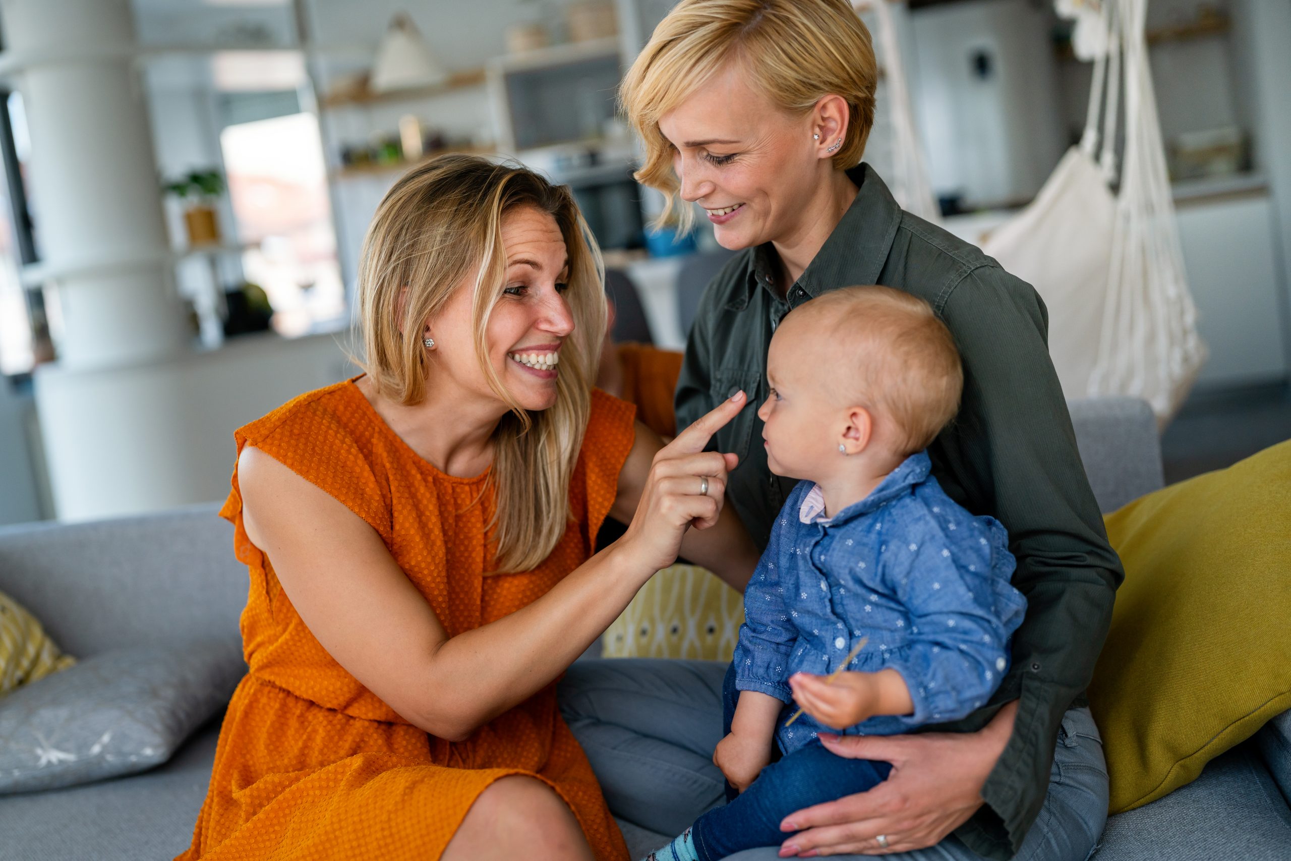 Happy lesbian couple with little girl at home after IVF family building